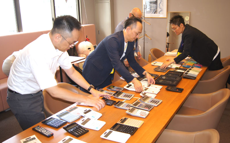 電卓をテーブルに並べる様子