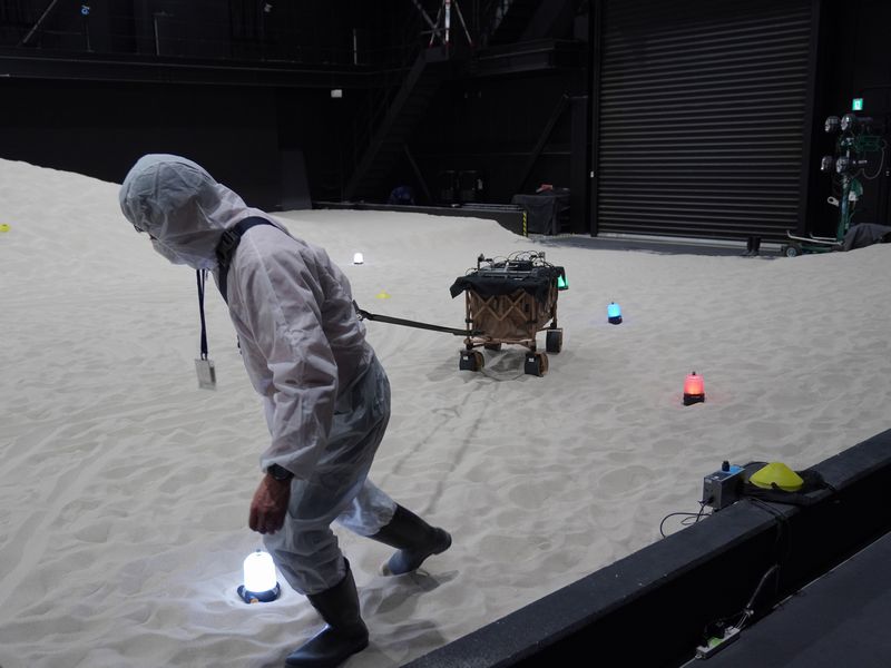 屋内実験場で月面探索車に見立てた台車にカメラとコンピュータを積み込んで測位する様子