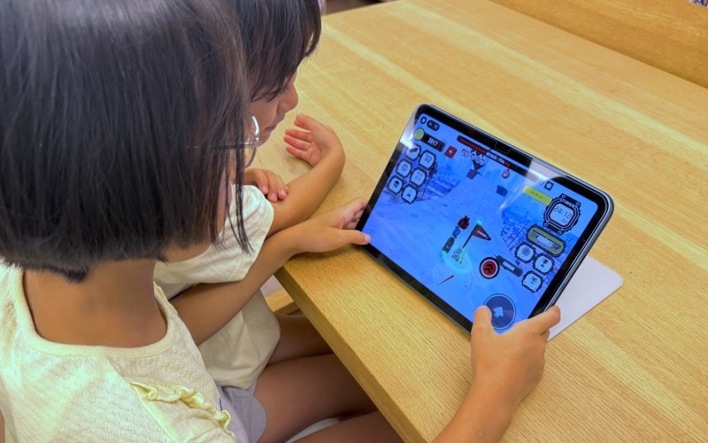 子供たちがゲームで遊んでいる様子の画像