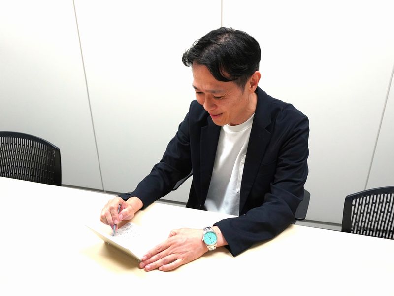電子辞書を使用する宮崎 一誠 支店長の画像